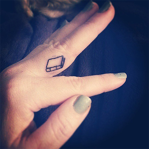 Small and cute book tattoo in girls hand
