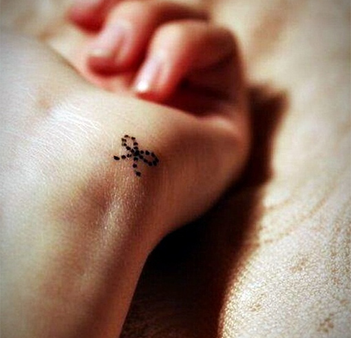 Small cute bow tattoo on hand